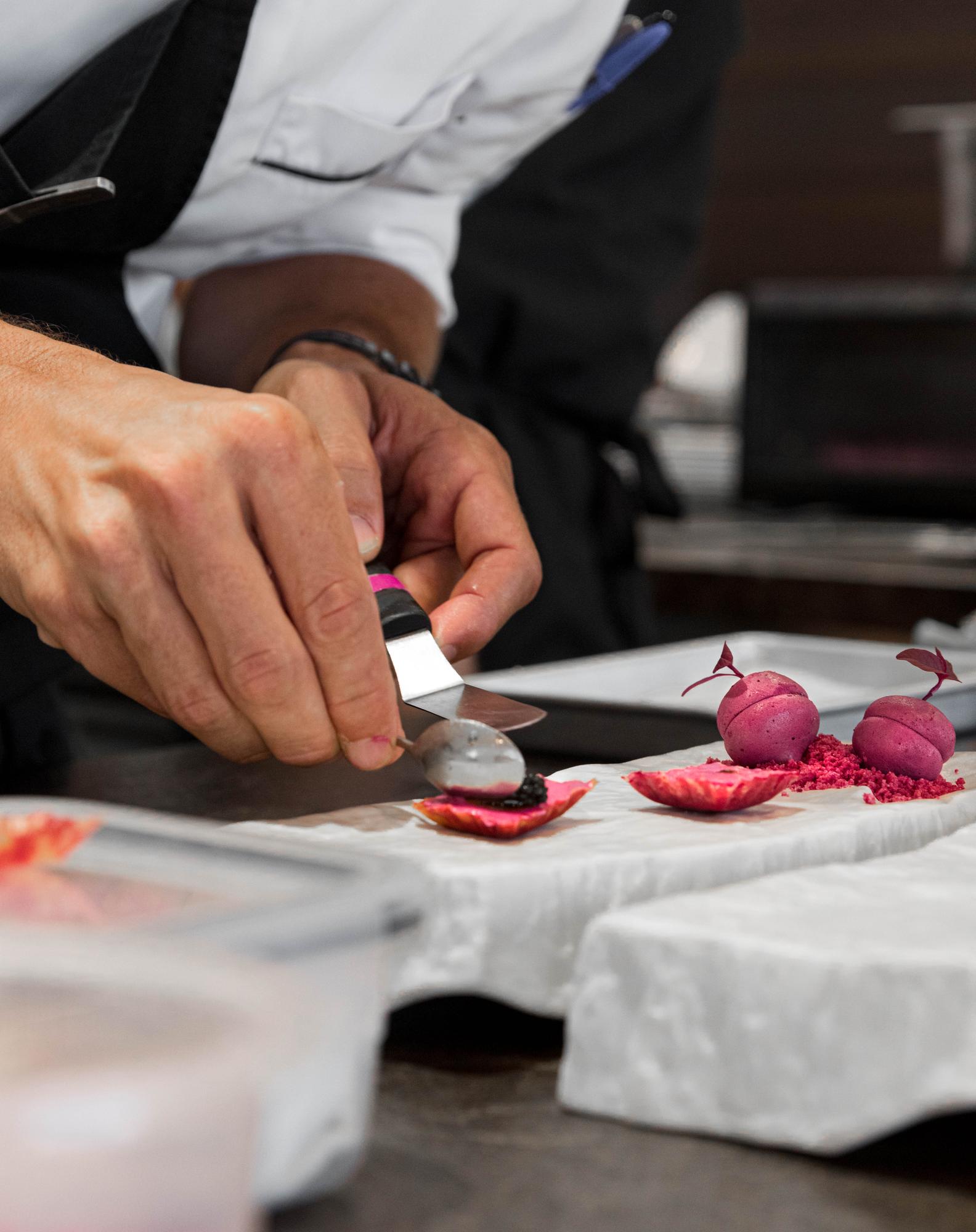 Chef demonstrando técnica de corte em cozinha profissional
